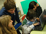 Mathías explica a Facu, Vero (la mamá de Facu) y Araceli como usa la computadora. La actividad formó parte de una clase abierta de informática 