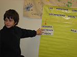 Un alumno completa un afiche con las características de las personas con discapacidad visual